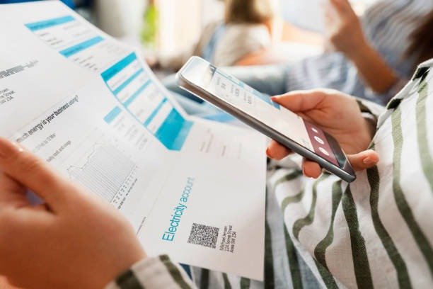 A woman checks her bank account on her smartphone, focused on managing her finances with professional credit counseling support.